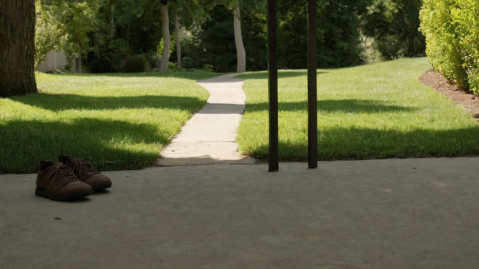 Plain walking shoes at the edge of a driveway beside a curved neighborhood path